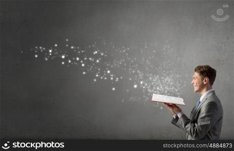 Businessman with red book. Smiling businessman in suit holding red opened book