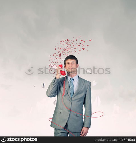 Businessman with red receiver. Handsome businessman talking on red phone handset