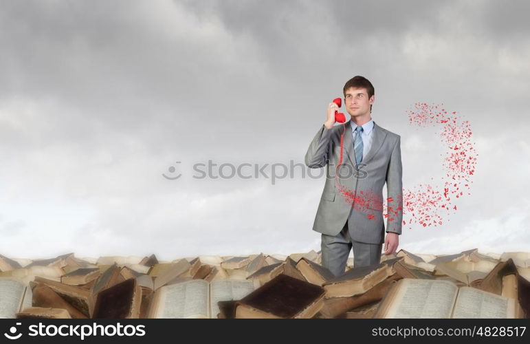 Businessman with red receiver. Handsome businessman talking on red phone handset