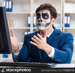 Businessman with scary face mask working in office. Businessmsn with scary face mask working in office