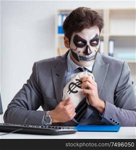 Businessman with scary face mask working in office. Businessmsn with scary face mask working in office