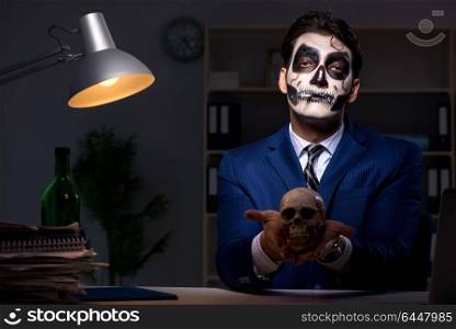 Businessman with scary face mask working late in office