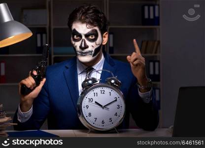 Businessman with scary face mask working late in office