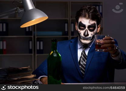 Businessman with scary face mask working late in office