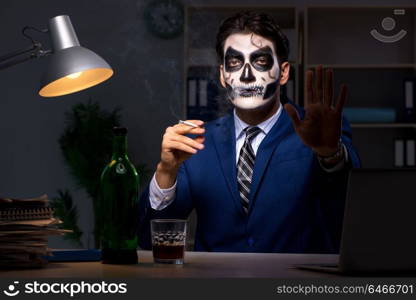 Businessman with scary face mask working late in office