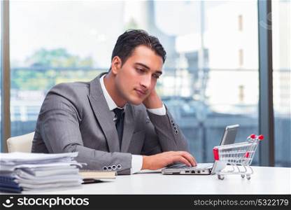 Businessman with shopping cart in office