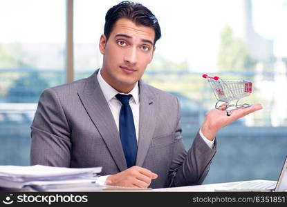 Businessman with shopping cart in office