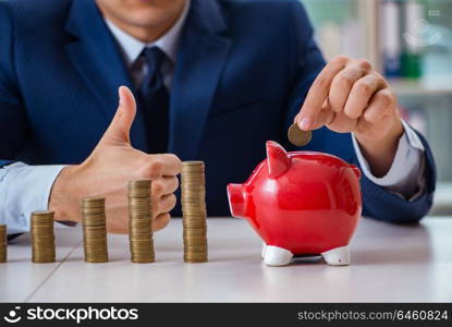 Businessman with stacks of coins in the office