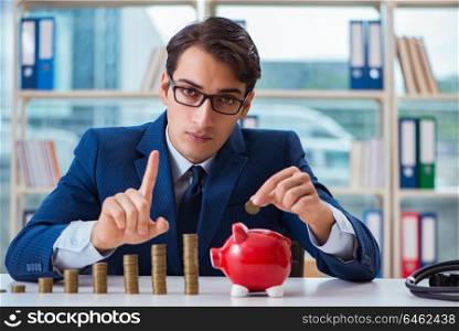Businessman with stacks of coins in the office