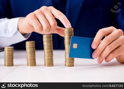 Businessman with stacks of coins in the office