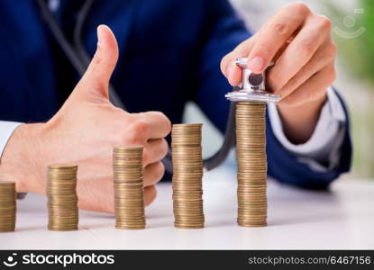 Businessman with stacks of coins in the office