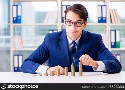 Businessman with stacks of coins in the office