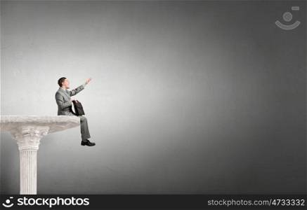 Businessman with suitcase. Young emotional businessman with briefcase in hands