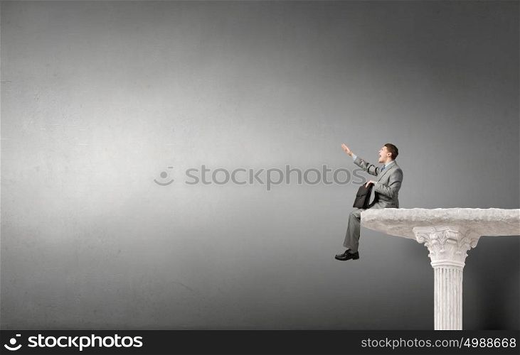 Businessman with suitcase. Young emotional businessman with briefcase in hands