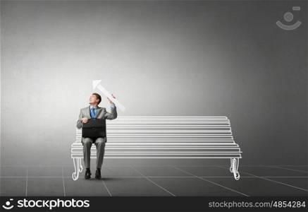 Businessman with suitcase. Young handsome businessman with briefcase and arrow in hands