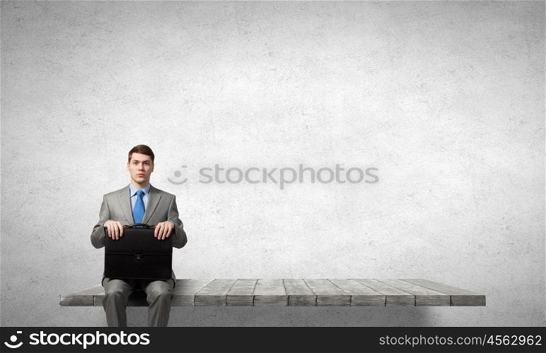 Businessman with suitcase. Young handsome businessman with briefcase in hands