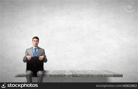 Businessman with suitcase. Young handsome businessman with briefcase in hands