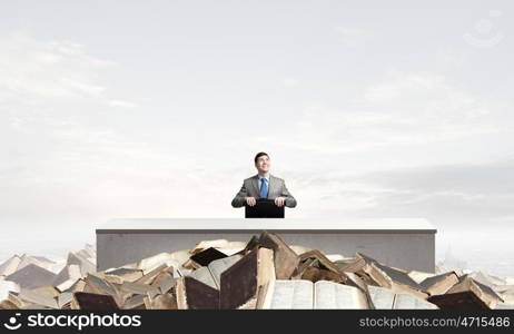 Businessman with suitcase. Young smiling businessman sitting with briefcase in hands