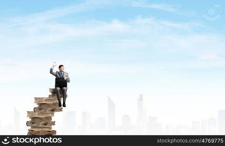 Businessman with suitcase. Young smiling businessman sitting with briefcase in hands