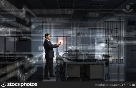 Businessman with tablet device in hands. Adult businessman in office dark interior using tablet pc