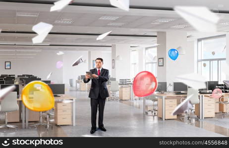 Businessman with tablet in hand. Adult businessman in modern office interior using tablet pc