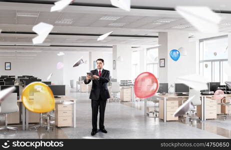 Businessman with tablet in hand. Adult businessman in modern office interior using tablet pc
