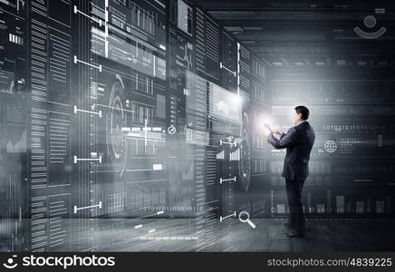 Businessman with tablet pc. Businessman on digital futuristic background using his tablet pc