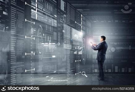Businessman with tablet pc. Businessman on digital futuristic background using his tablet pc