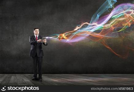 Businessman with tablet pc. Businessman using his tablet pc and glowing light out of screen