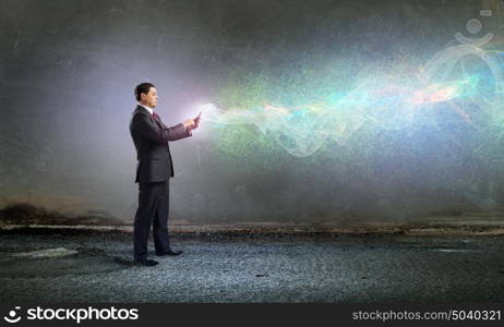 Businessman with tablet pc. Businessman using his tablet pc and glowing light out of screen