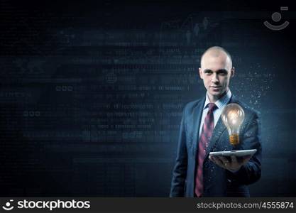 Businessman with tablet. Young businessman presenting tablet pc with glass lightbulb on it