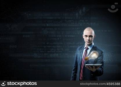 Businessman with tablet. Young businessman presenting tablet pc with glass lightbulb on it