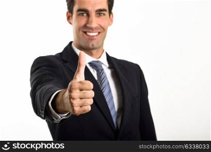 Businessman with thumb up wearing blue suit and tie on white background. Man with formal clothes in studio.