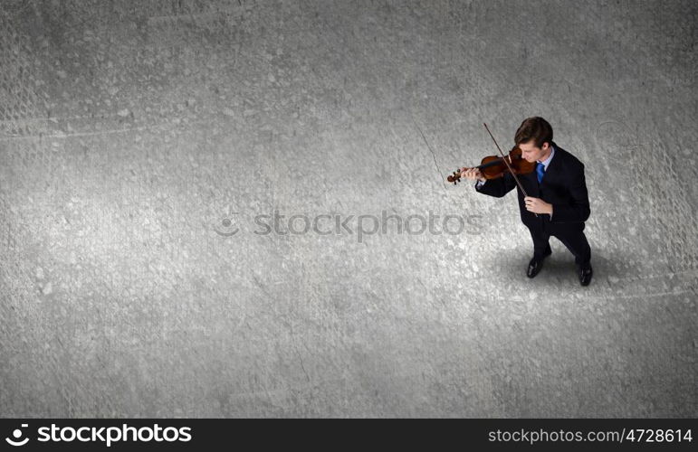 Businessman with violin. Top view of young businessman playing violin