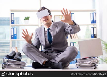 Businessman with VR virtual reality glasses in office