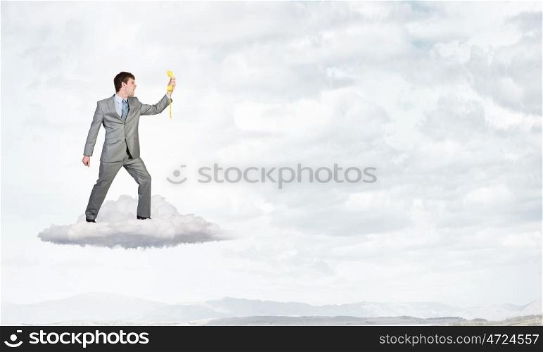 Businessman with yellow receiver. Handsome businessman talking on yellow phone handset