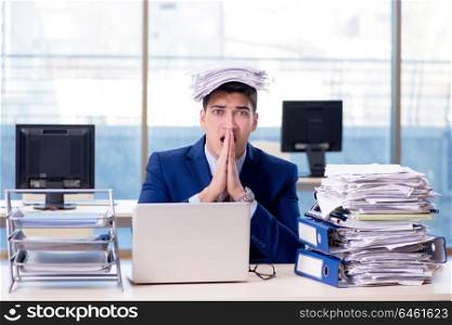 Businessman workaholic struggling with pile of paperwork