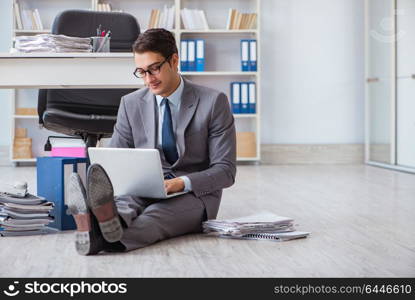 Businessman working and sitting on floor in office