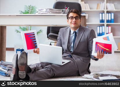 Businessman working and sitting on floor in office