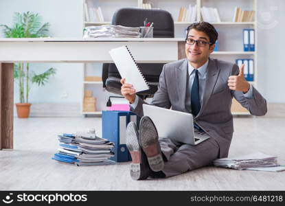 Businessman working and sitting on floor in office