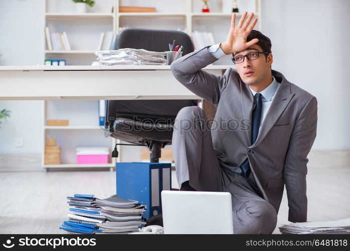 Businessman working and sitting on floor in office