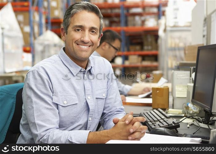 Businessman Working At Desk In Warehouse