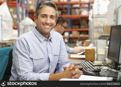 Businessman Working At Desk In Warehouse