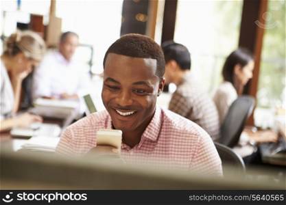 Businessman Working At Desk Using Mobile Phone