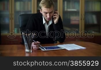 Businessman Working At His Desk Takes A Phone Call