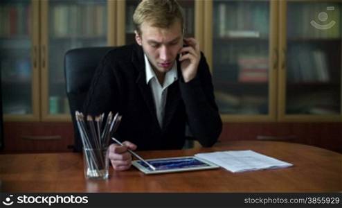 Businessman Working At His Desk Takes A Phone Call