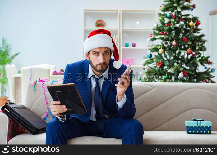 Businessman working at home during christmas. The businessman working at home during christmas