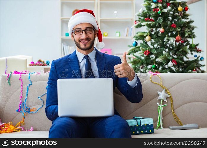 Businessman working at home during christmas. The businessman working at home during christmas