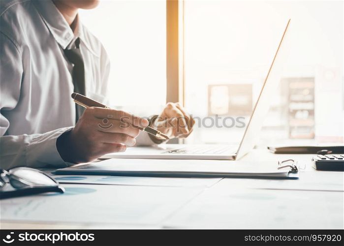 Businessman working at office room and using laptop.