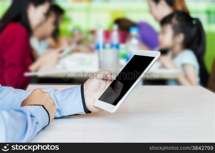 Businessman working by using digital tablet in food center